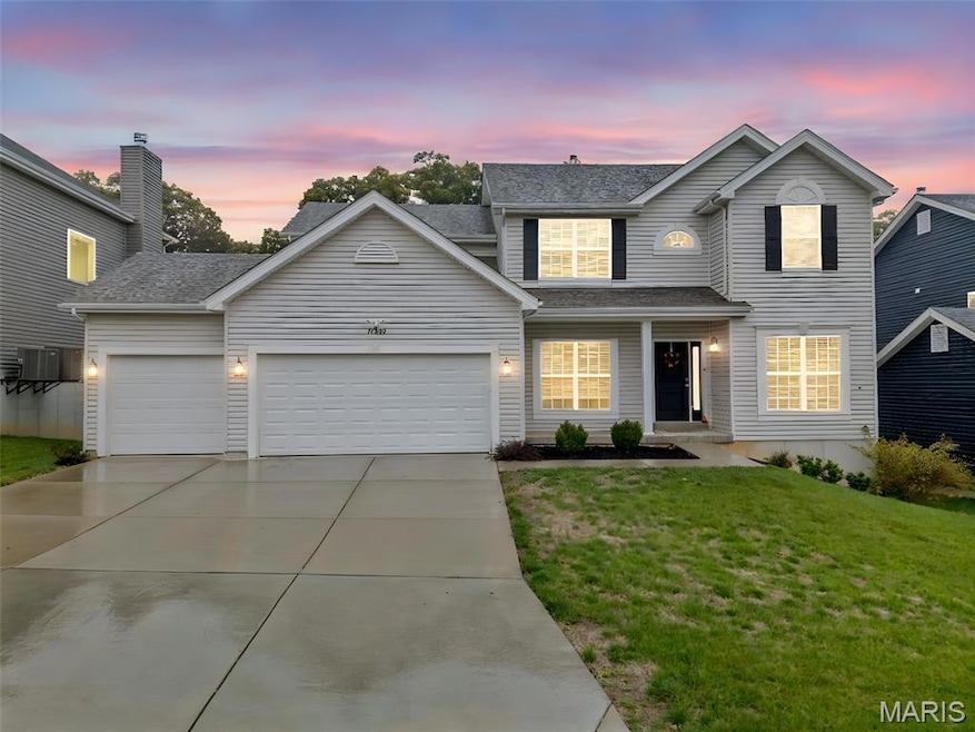 Traditional home with driveway, a lawn, a garage, and a shingled roof