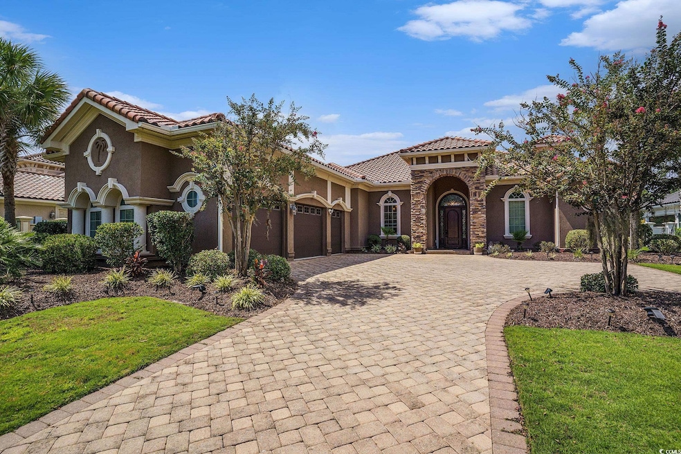 Mediterranean / spanish-style home with decorative driveway, stucco siding, a front yard, stone siding, and a tile roof