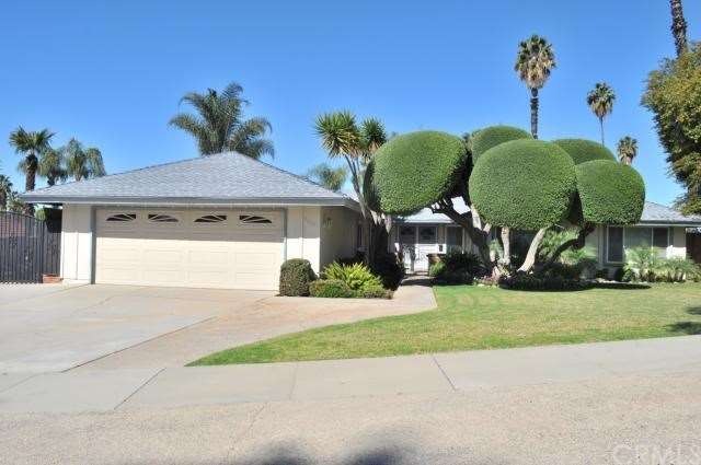 Front of house, with gated parking on the left, an