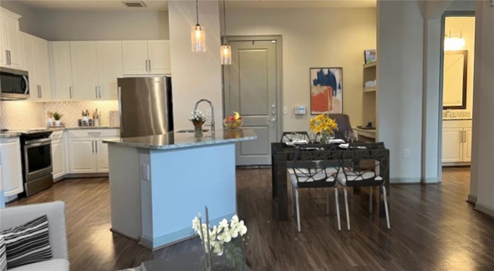Kitchen featuring stainless steel appliances, whit