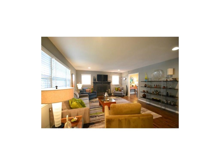 Tasteful and chic living room opens to eating area