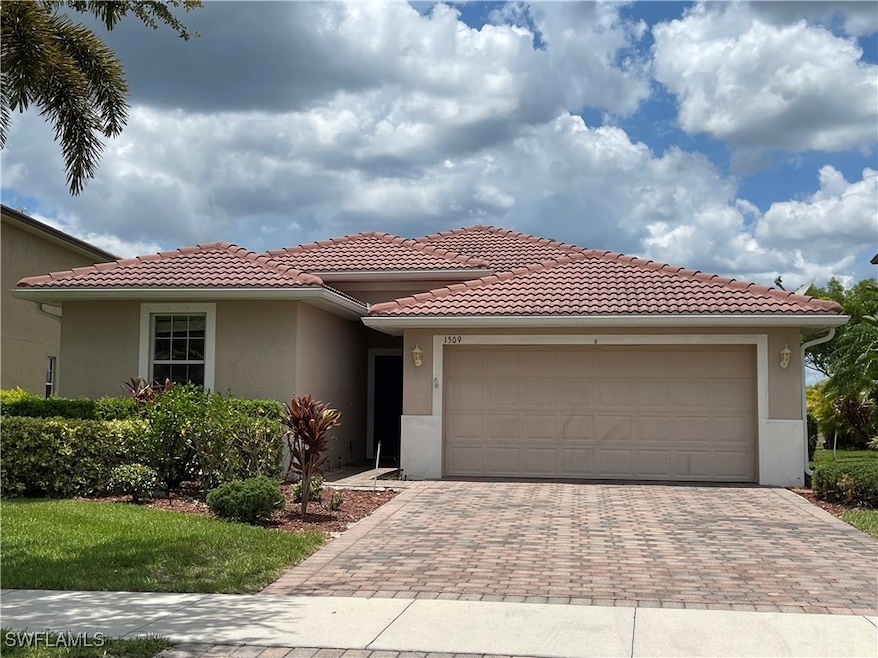 View of front of home with stucco siding, a garage, decorative driveway, and a tile roof