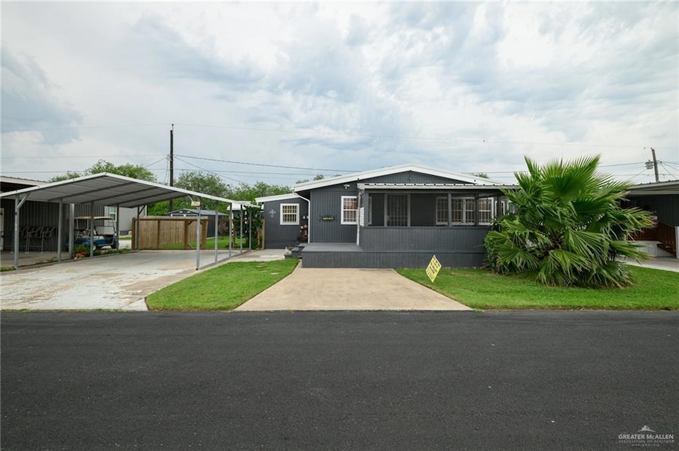 Manufactured / mobile home featuring a detached carport and driveway