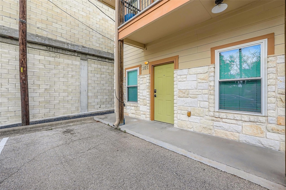 Doorway to property with stone siding and a balco