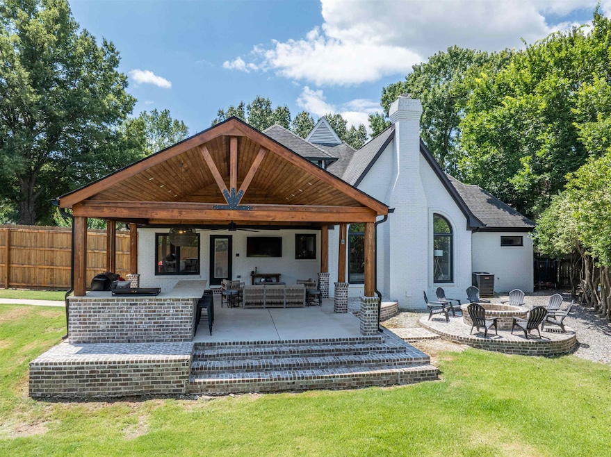 Back of house with a chimney, a patio area, an outdoor living space with a fire pit, and roof with shingles