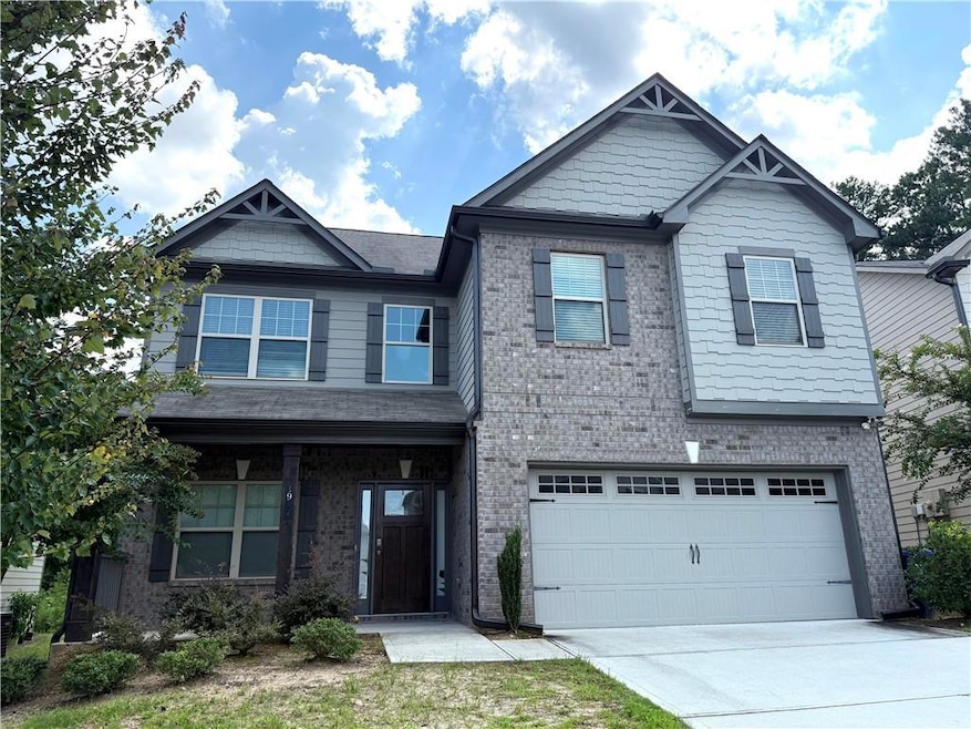 Craftsman house featuring a porch, a garage, driveway, and brick siding