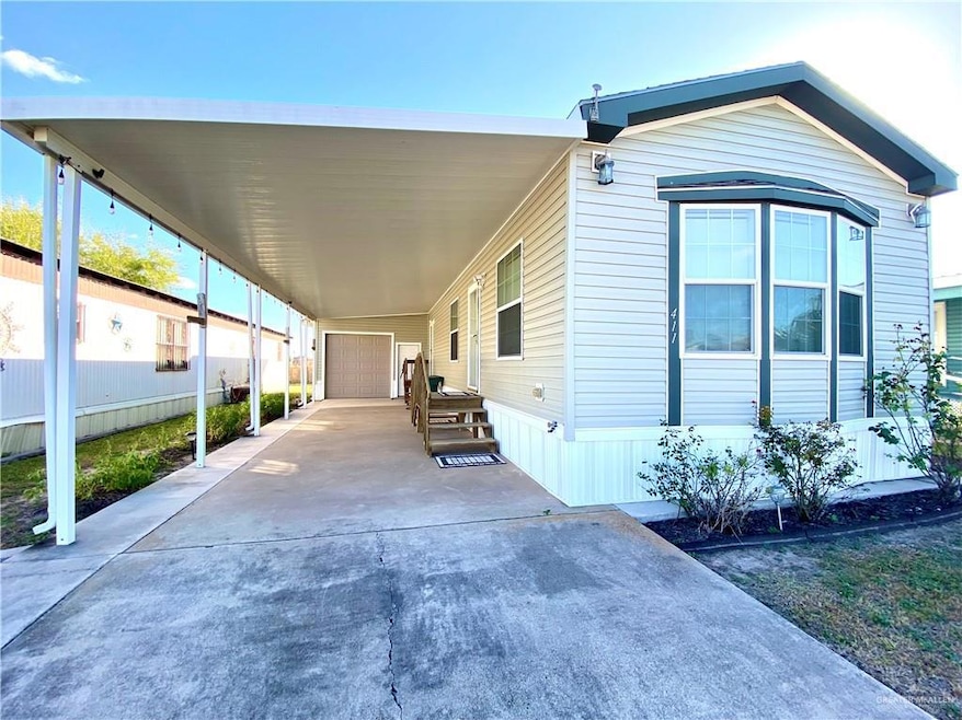 View of front of property with driveway, a carport, and a garage
