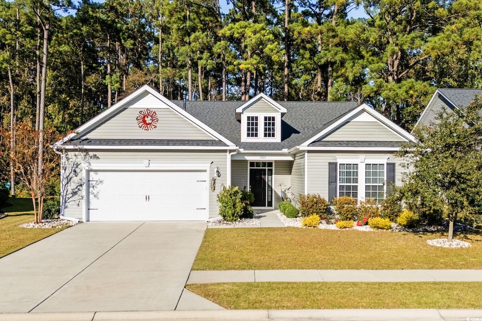 View of front of house featuring roof with shingles, an attached garage, driveway, and a front lawn