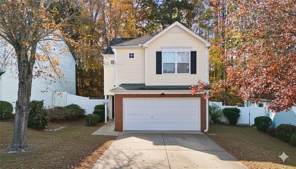 Traditional home featuring driveway, an attached garage, brick siding, and a shingled roof
