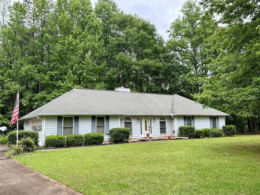 Single story home featuring a front yard, a chimne