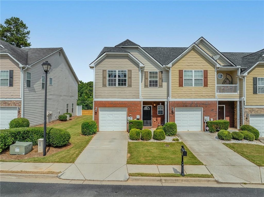 View of front facade with concrete driveway, brick siding, a garage, and a front yard