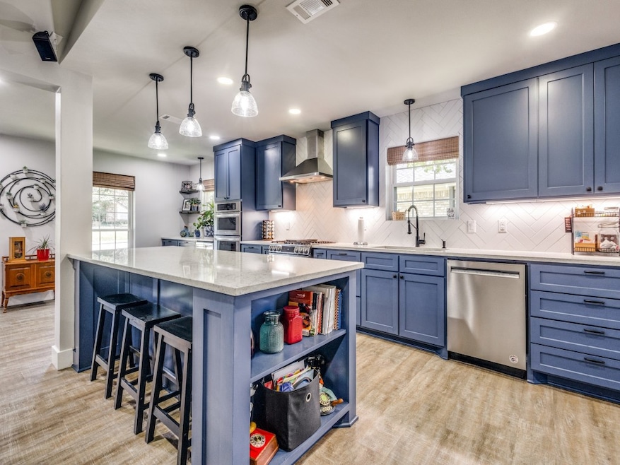 Kitchen with open shelves, blue cabinetry, tasteful backsplash, stainless steel appliances, and recessed lighting