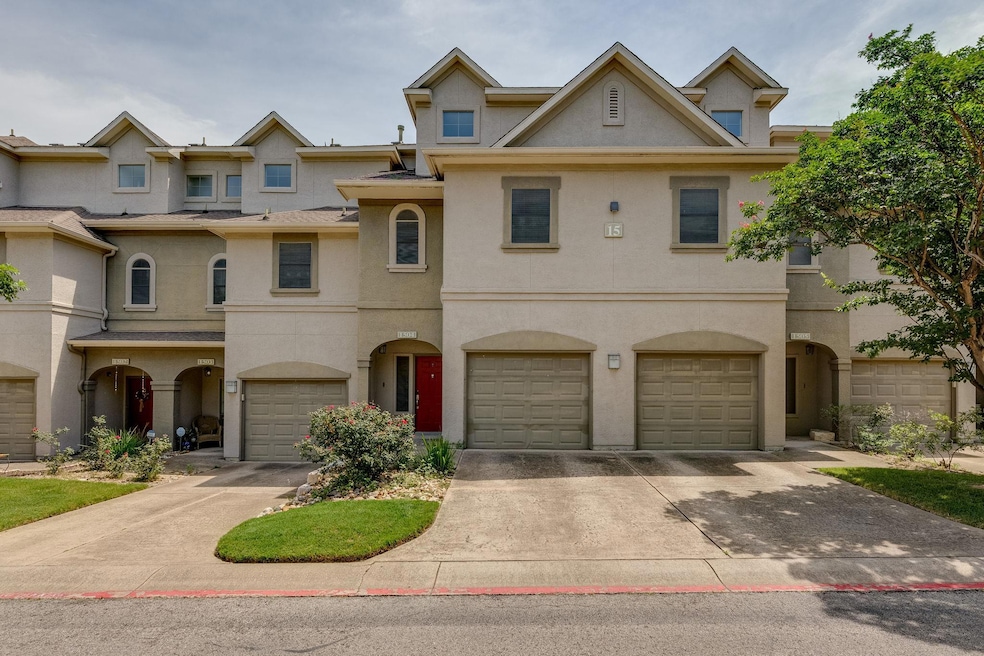 View of property featuring stucco siding, drivewa