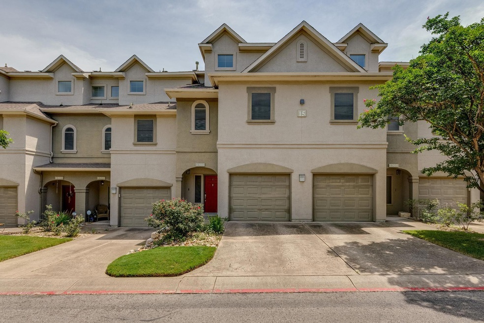 View of property featuring stucco siding, drivewa