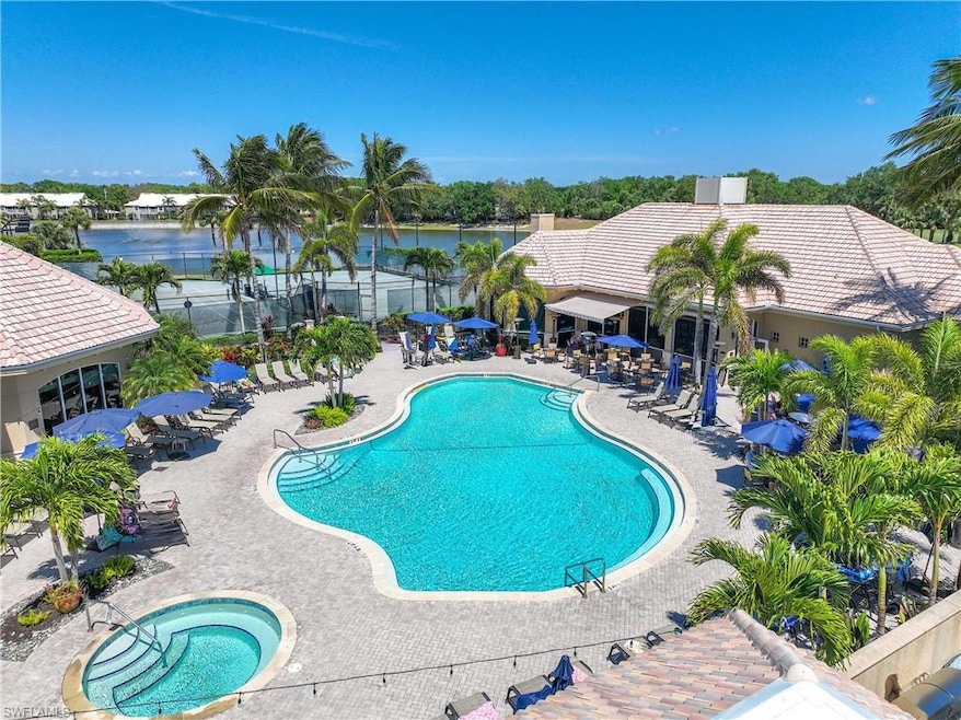 Community pool with a patio area, a water view, an