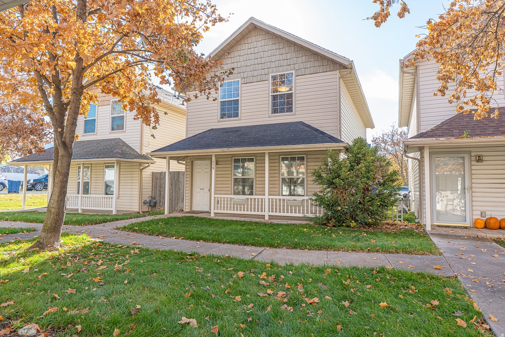 View of front of house with a porch, a front lawn, and roof with shingles