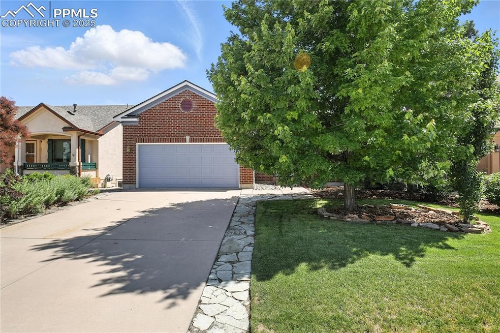 View of front of house featuring concrete driveway, brick siding, and an attached garage