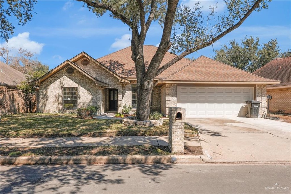 View of front facade with a shingled roof, brick siding, driveway, and an attached garage
