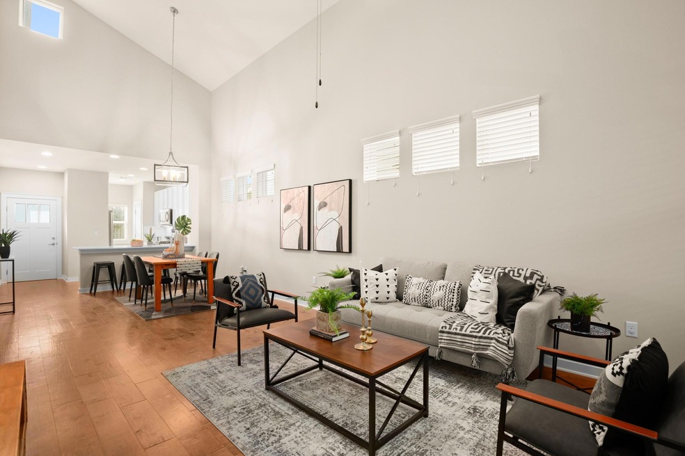 Living room featuring high vaulted ceiling, light