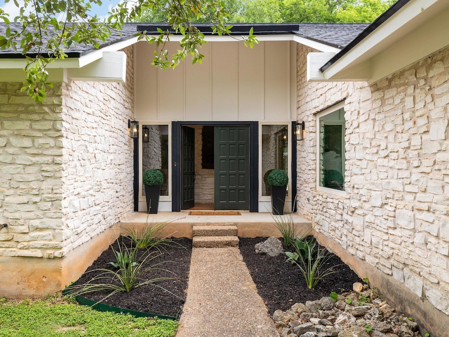 Property entrance with stone siding and board and
