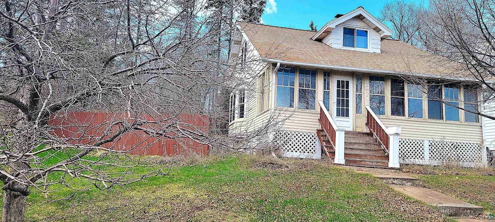 View of front facade featuring entry steps, roof with shingles, and a front yard
