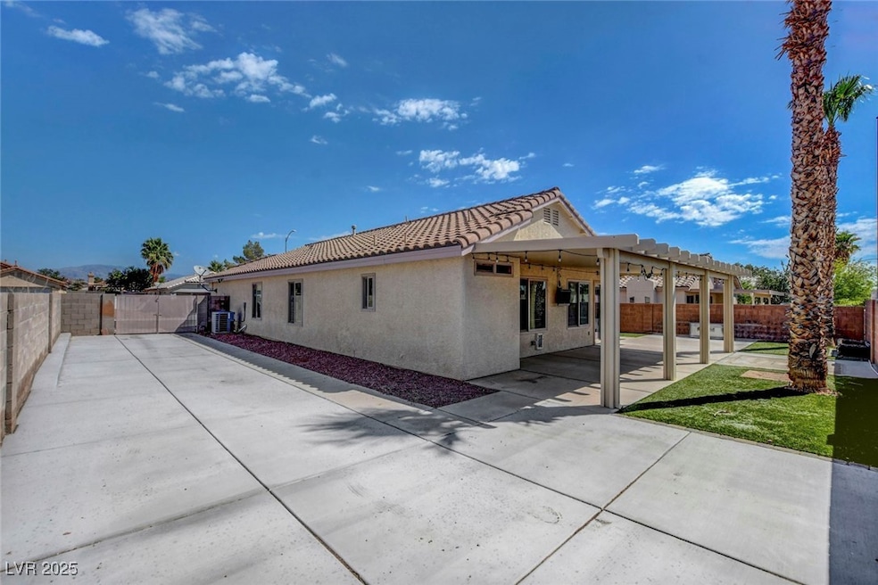 Rear view of house featuring a fenced backyard, a patio area, stucco siding, a pergola, and a tile roof