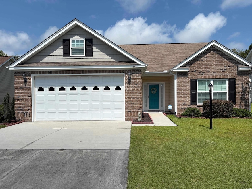 View of front of property featuring concrete driveway, a front yard, roof with shingles, and brick siding