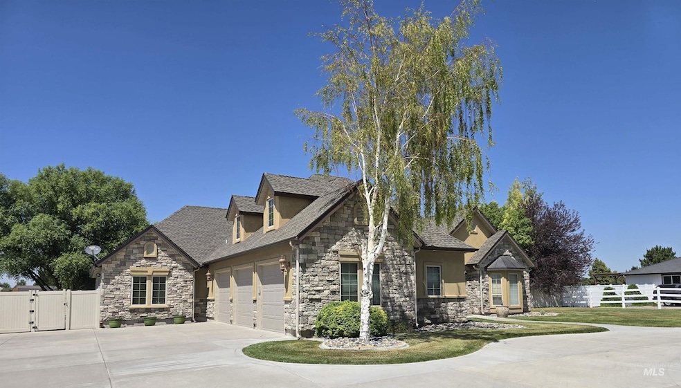 View of front of property featuring stone siding, an attached garage, a gate, and driveway