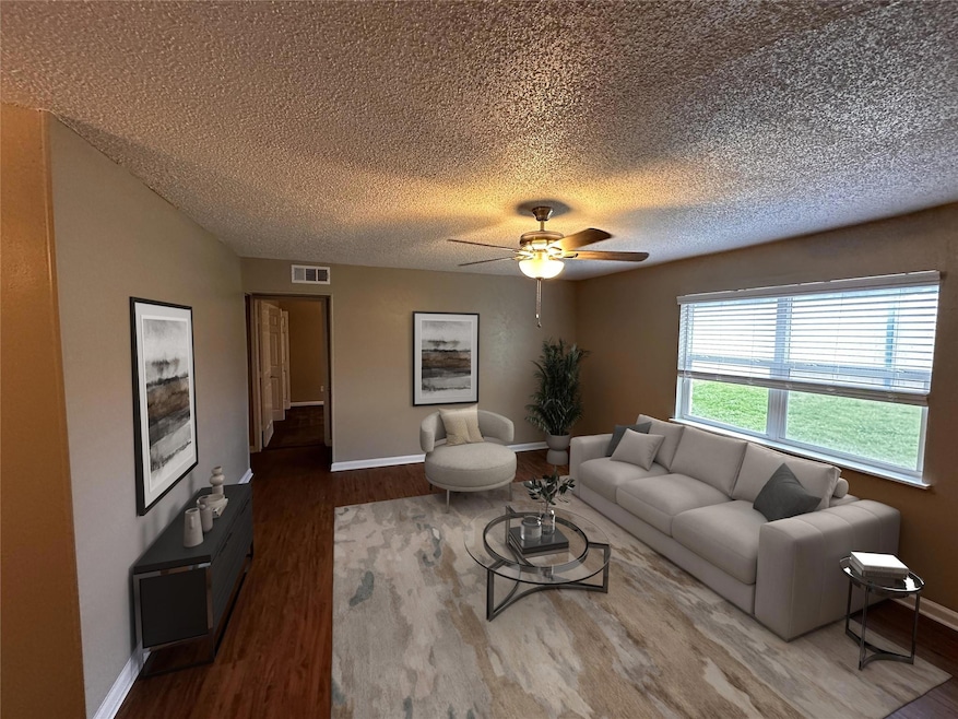 Living room with a ceiling fan, wood finished floo