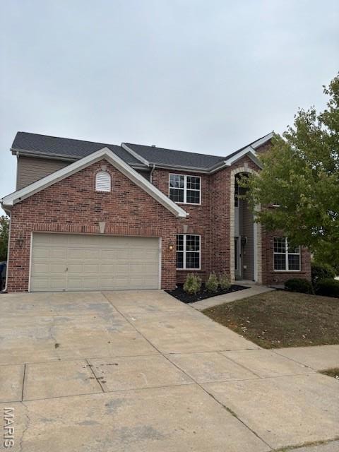 Traditional home with driveway, brick siding, and an attached garage