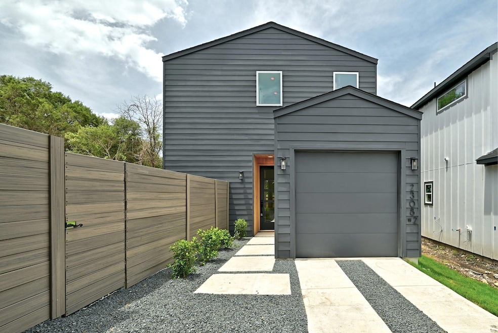 View of front facade with fence, an attached gara