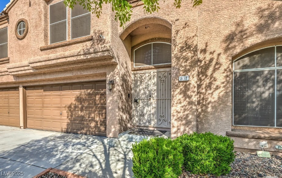 Doorway to property featuring a garage and drivewa