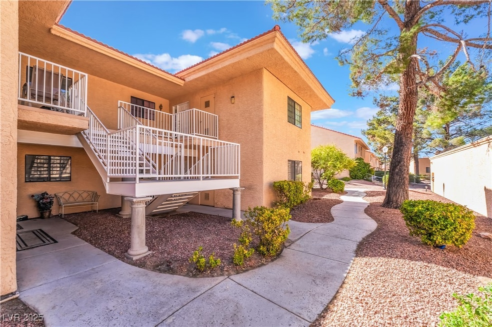 View of side of property featuring stairs and stucco siding