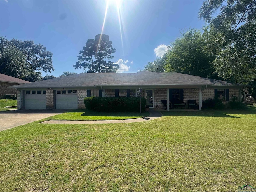 Ranch-style house with a garage, brick siding, driveway, and a front lawn