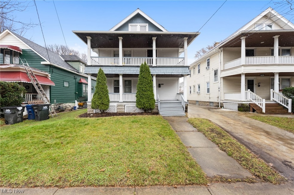 View of front of property featuring a front lawn, a porch, and a balcony
