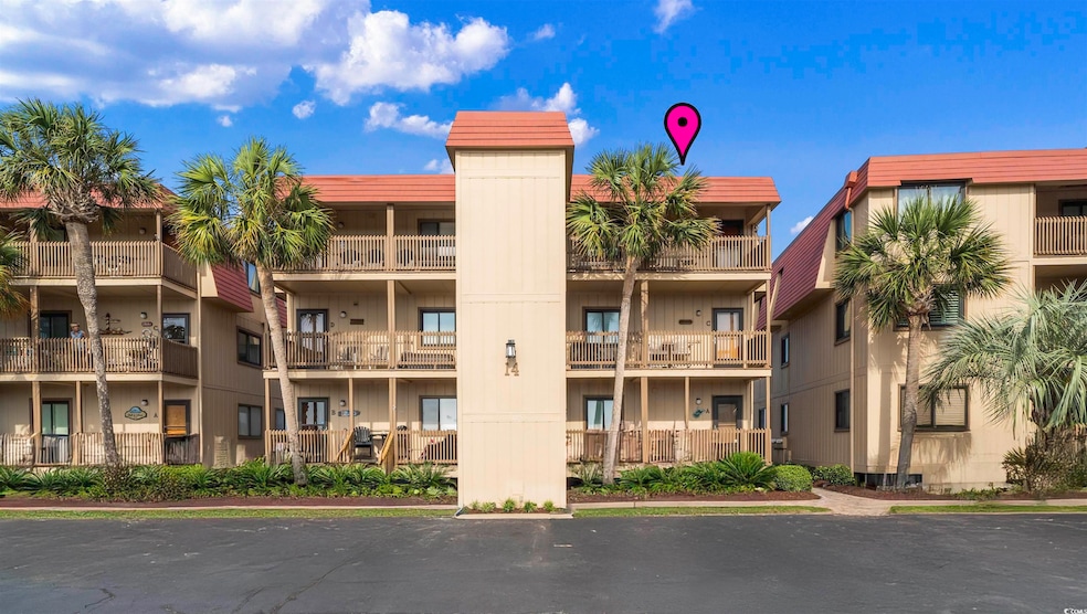 View of apartment building / complex with uncovered parking