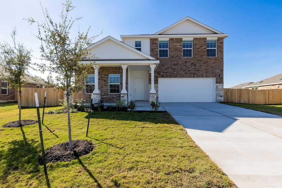 View of front facade with brick siding, driveway, a porch, and an attached garage