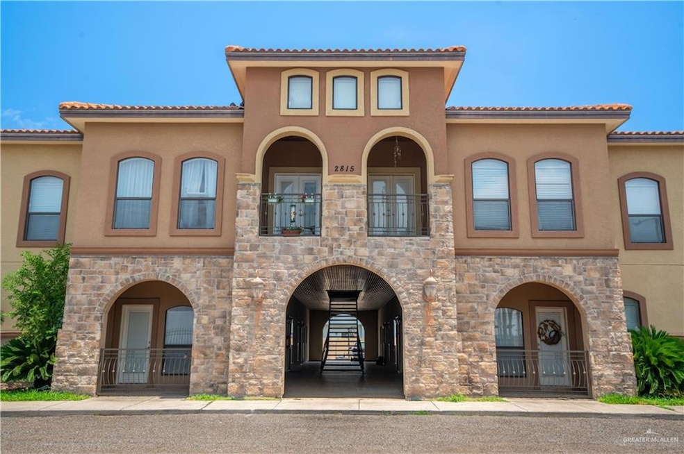 View of front of property featuring stucco siding, a balcony, and stone siding