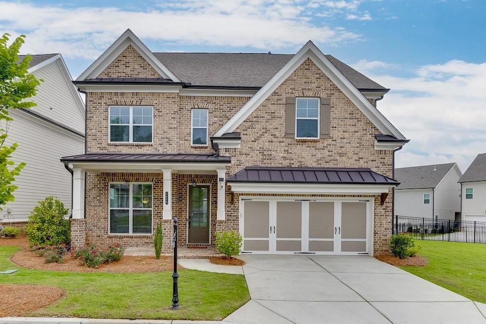 Craftsman-style home featuring driveway, an attached garage, brick siding, and a standing seam roof