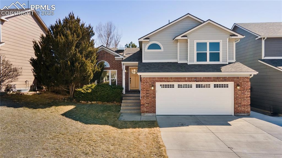 View of front of property featuring a garage, bric