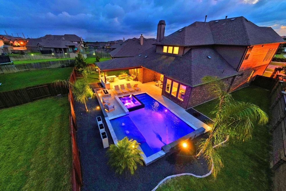 This is a Gorgeous Infinity Edge Pools and Hot Tub that create the visual effect of water vanishing or extending off into the horizon, as there are no visible edges on one side of the pool. I would describe an infinity pool also referred to as a vanishing edge or zero edge Swimming Pool because of this visual effect created by water as it spills over the edge!  Special Effect also from the stunning Gas Fire Pit and all the Night Lighting! Paradise! 