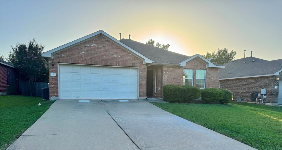 Ranch-style home with concrete driveway, brick si