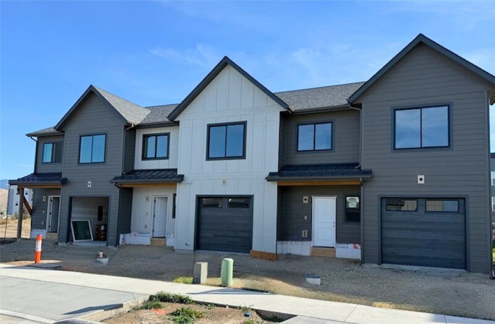 View of front of home with board and batten siding, driveway, and a garage