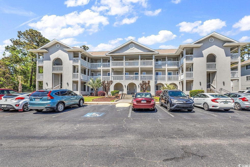 View of building exterior with uncovered parking