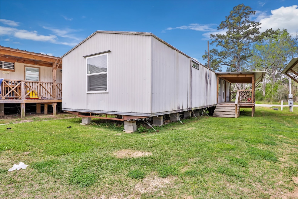 This photo shows a mobile home on a grassy lot, el