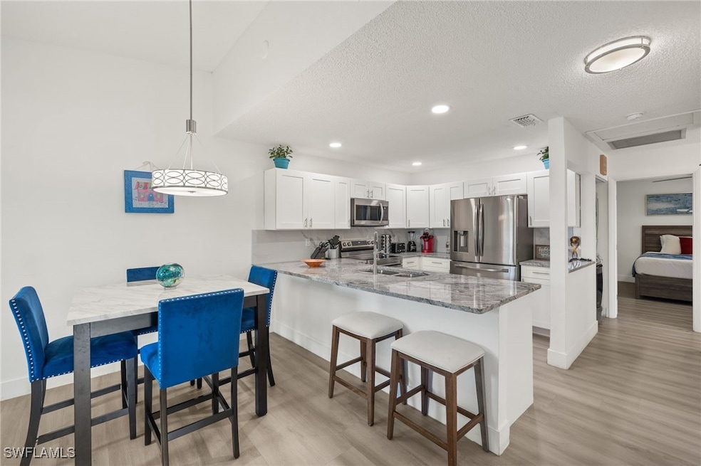 Kitchen with white cabinetry, sink, stainless stee