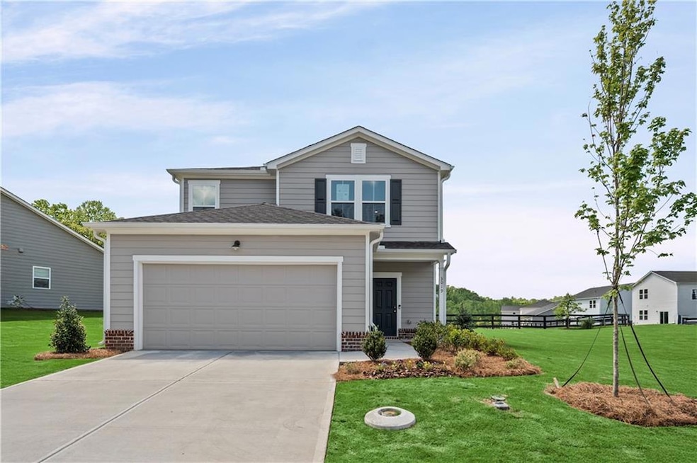 View of front facade with concrete driveway, a garage, and brick siding