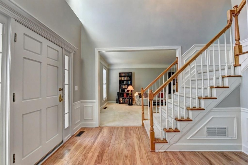 Beautiful light and bright foyer welcomes.  Newly refinished hardwood floors, front staircase.