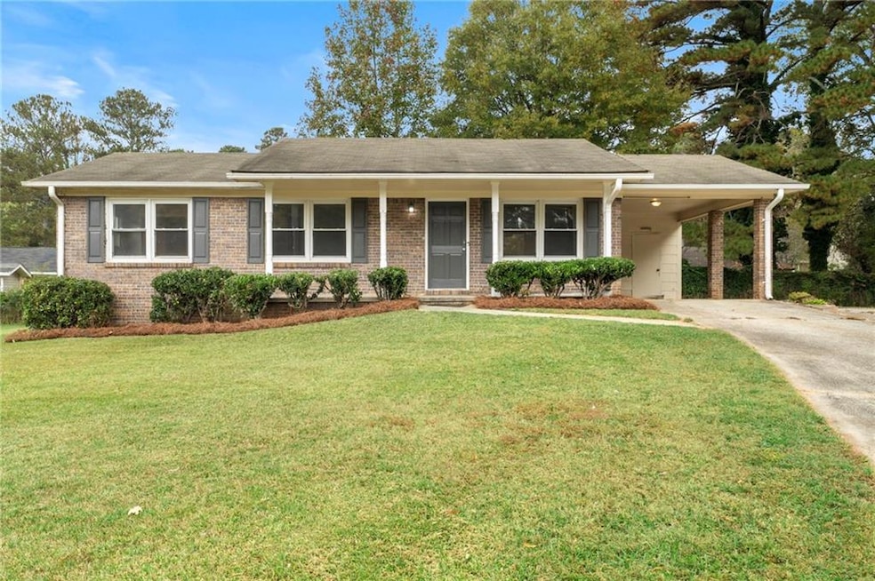 Ranch-style house featuring a front yard and a car