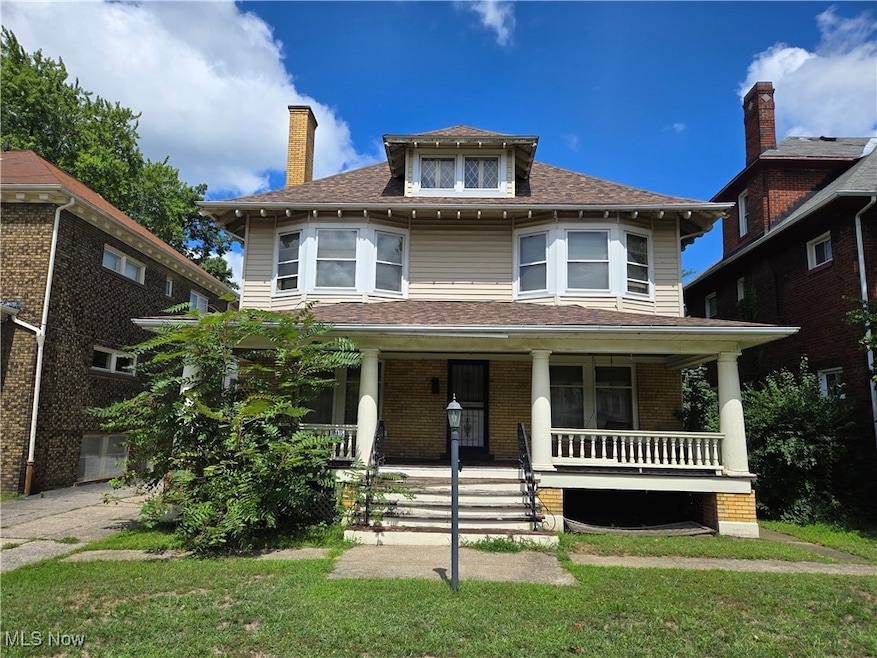 View of front facade featuring a front yard and covered porch